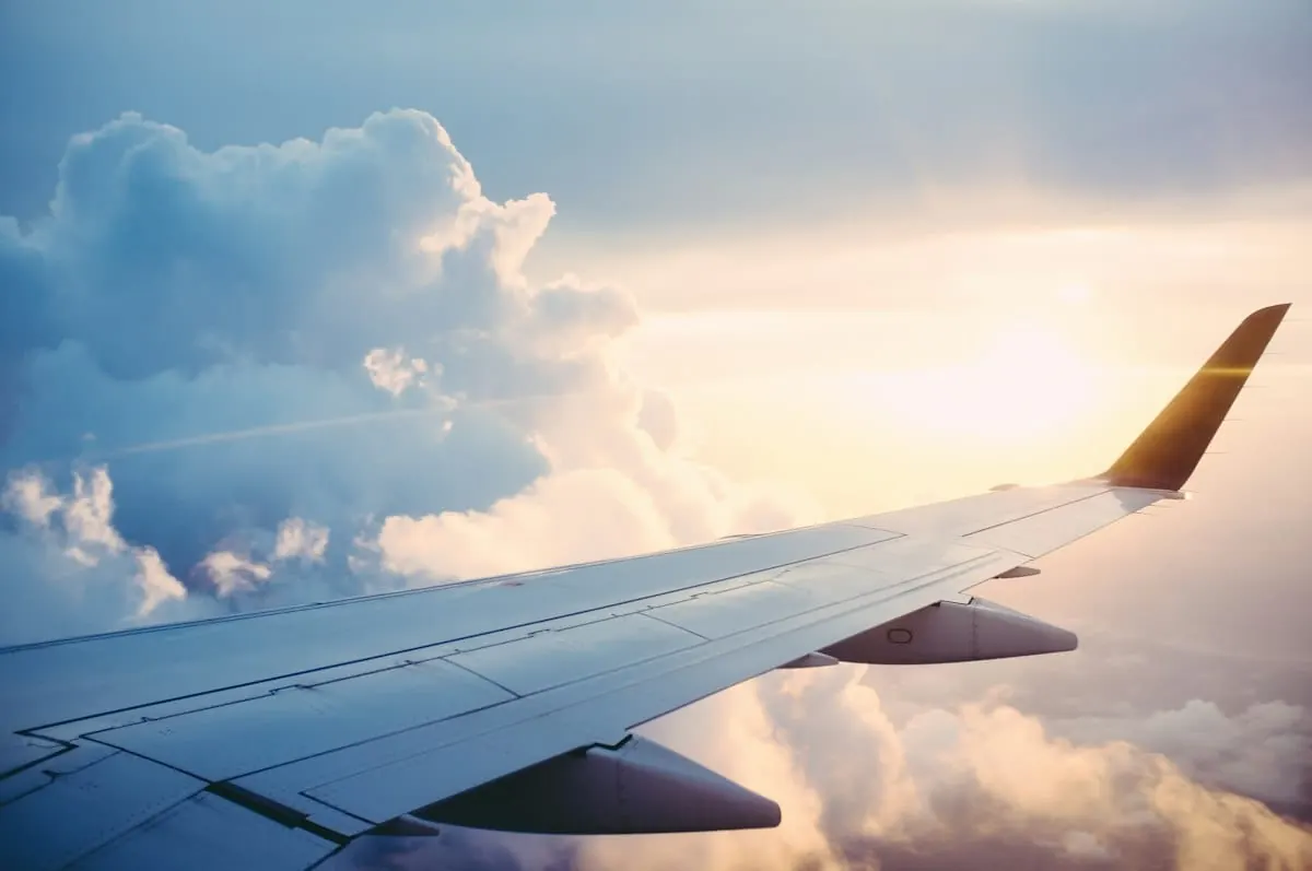 Passaporte, passagens aéreas e cartão de crédito em aeroporto representando o comparativo de seguro viagem